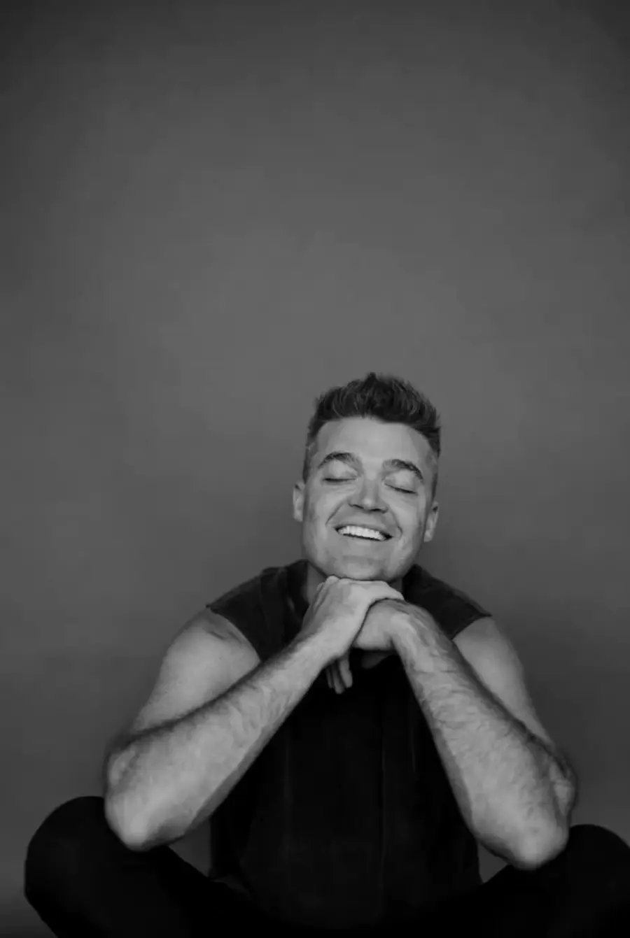 Nathan Morris sitting on the floor, laughing.